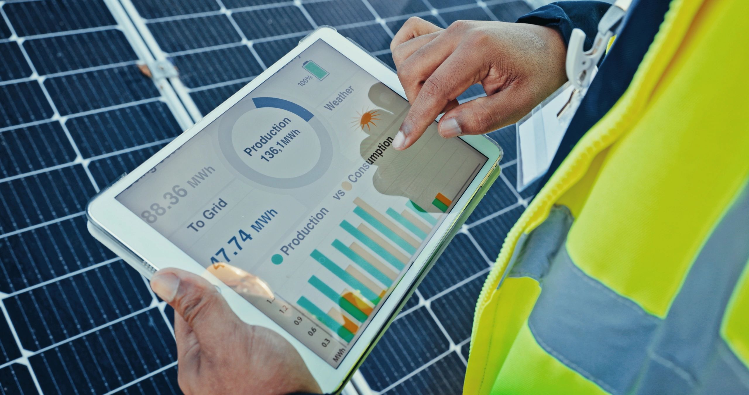 Technician holding a tablet showing solar monitoring data
