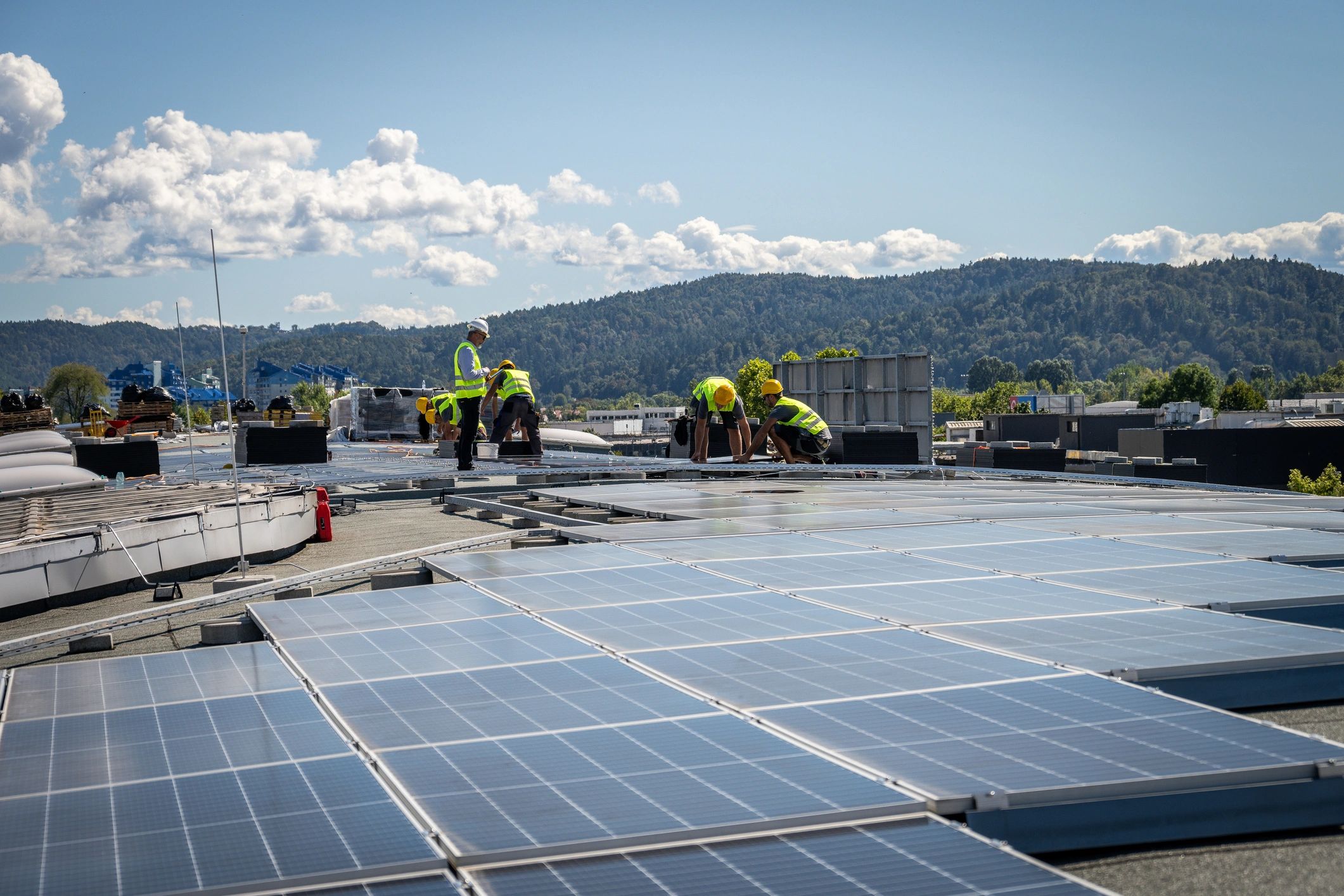 Workers coordinating rooftop solar installation