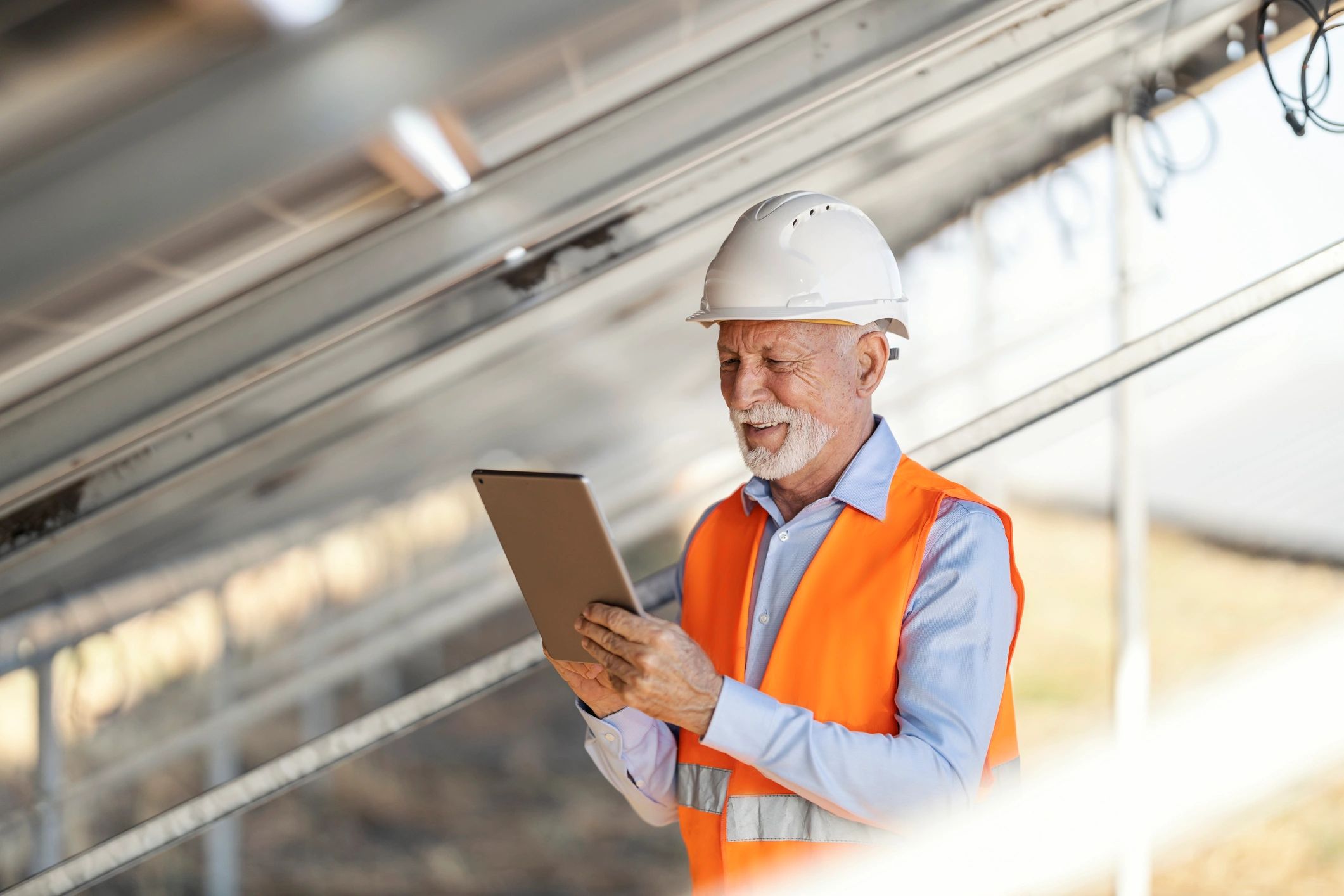 Engineer inspecting solar panels with a tablet