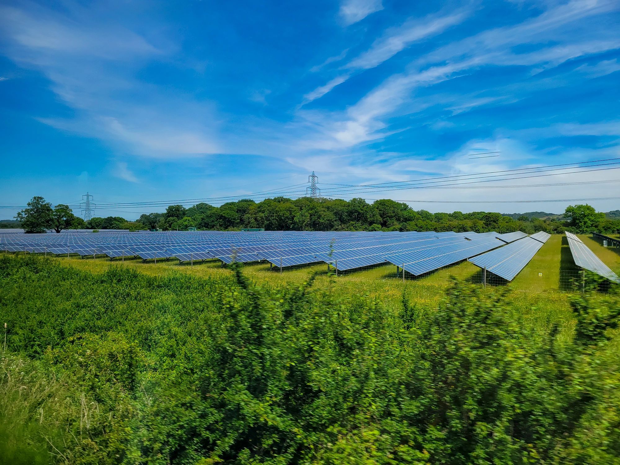 Rows of solar panels across a green field