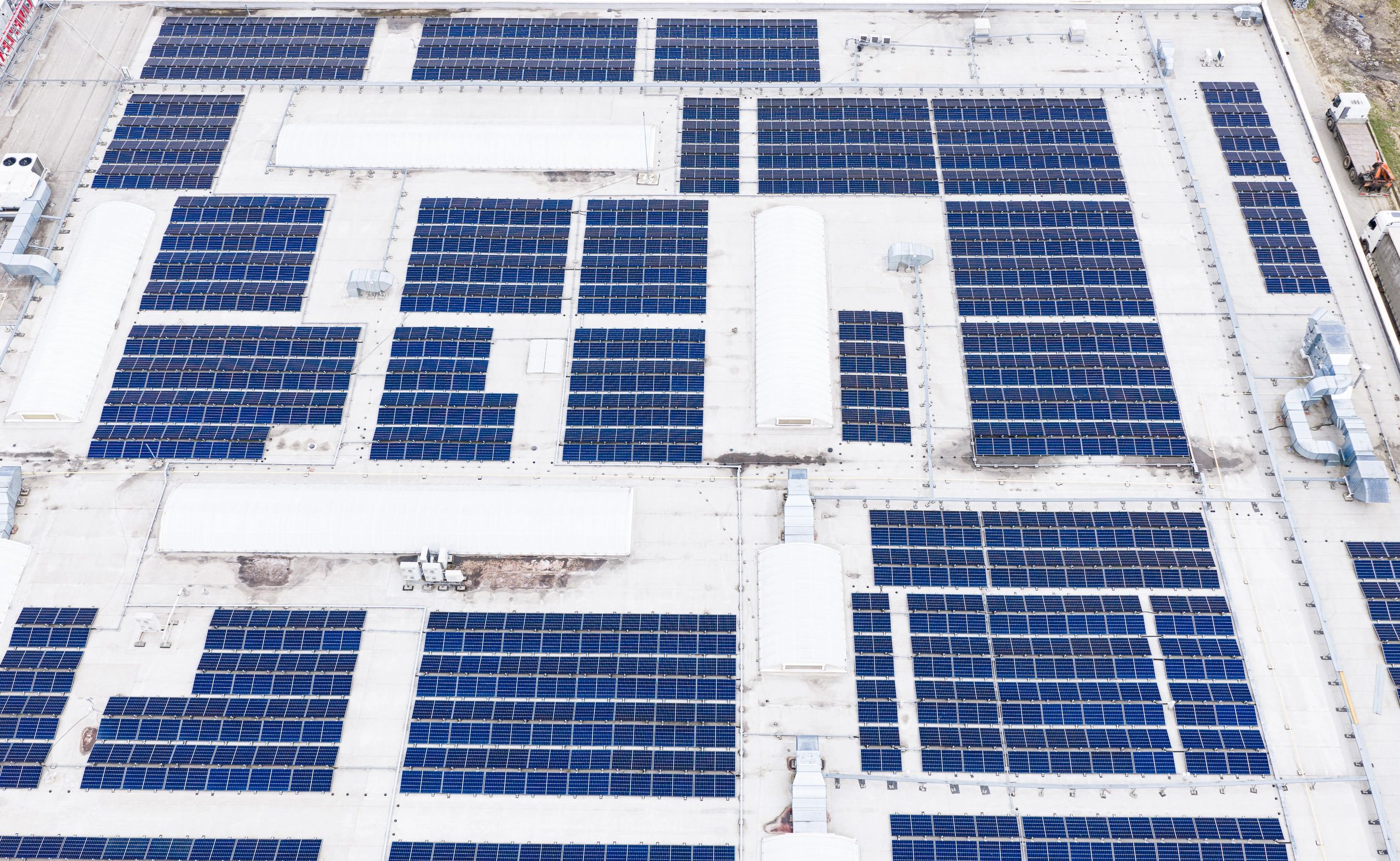 INDUSTRIAL rooftop covered with solar panels generating clean electricity